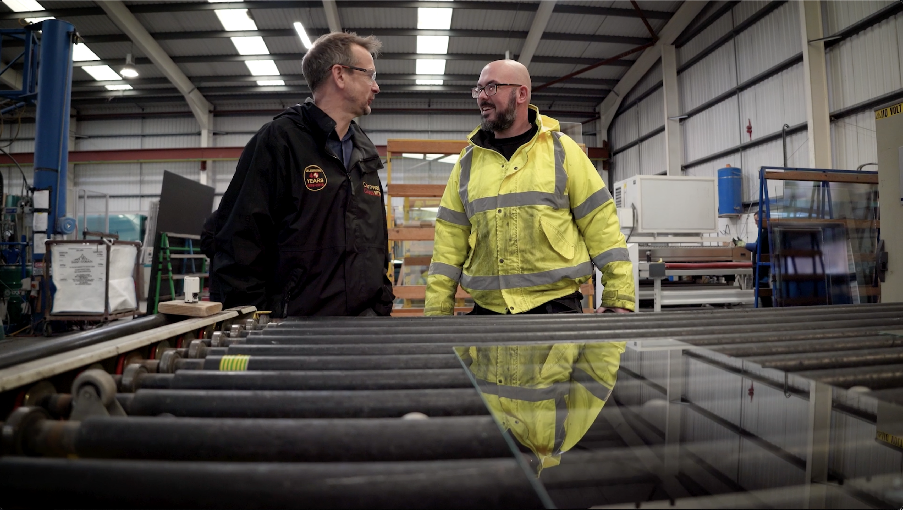 Two people smiling at each other in a factory