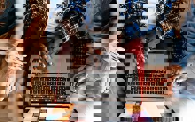 People sat down using and looking at a laptop