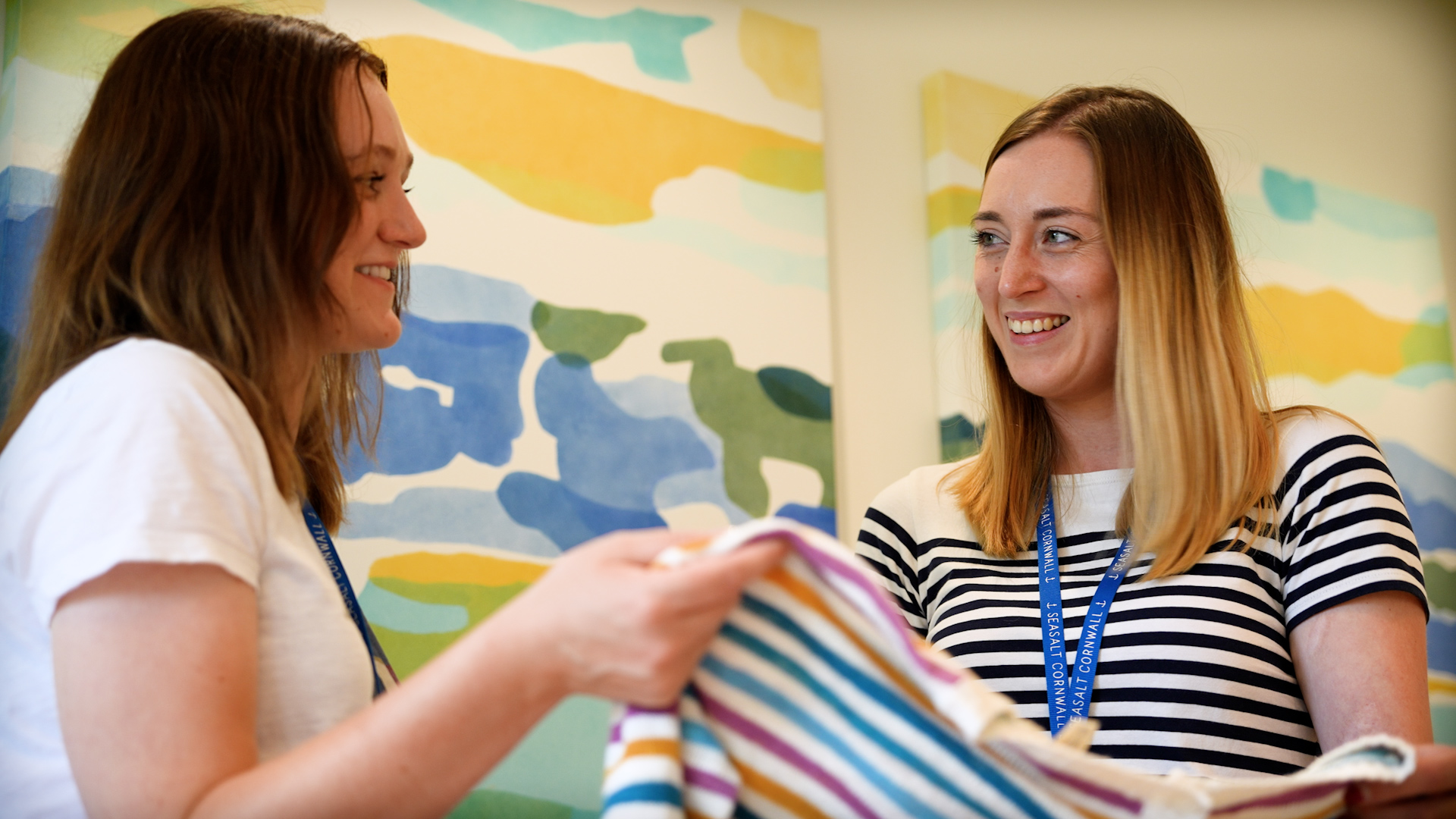 People working for Seasalt looking at a clothing item together smiling at each other