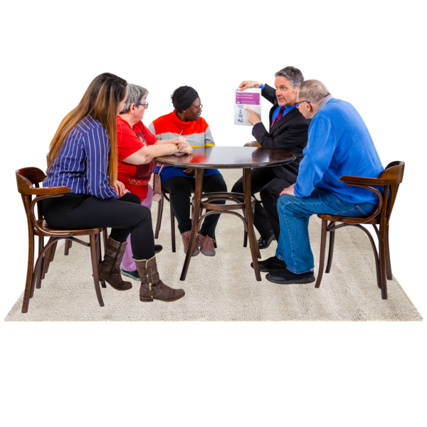 People sat around a table looking at a man who is pointing at a form