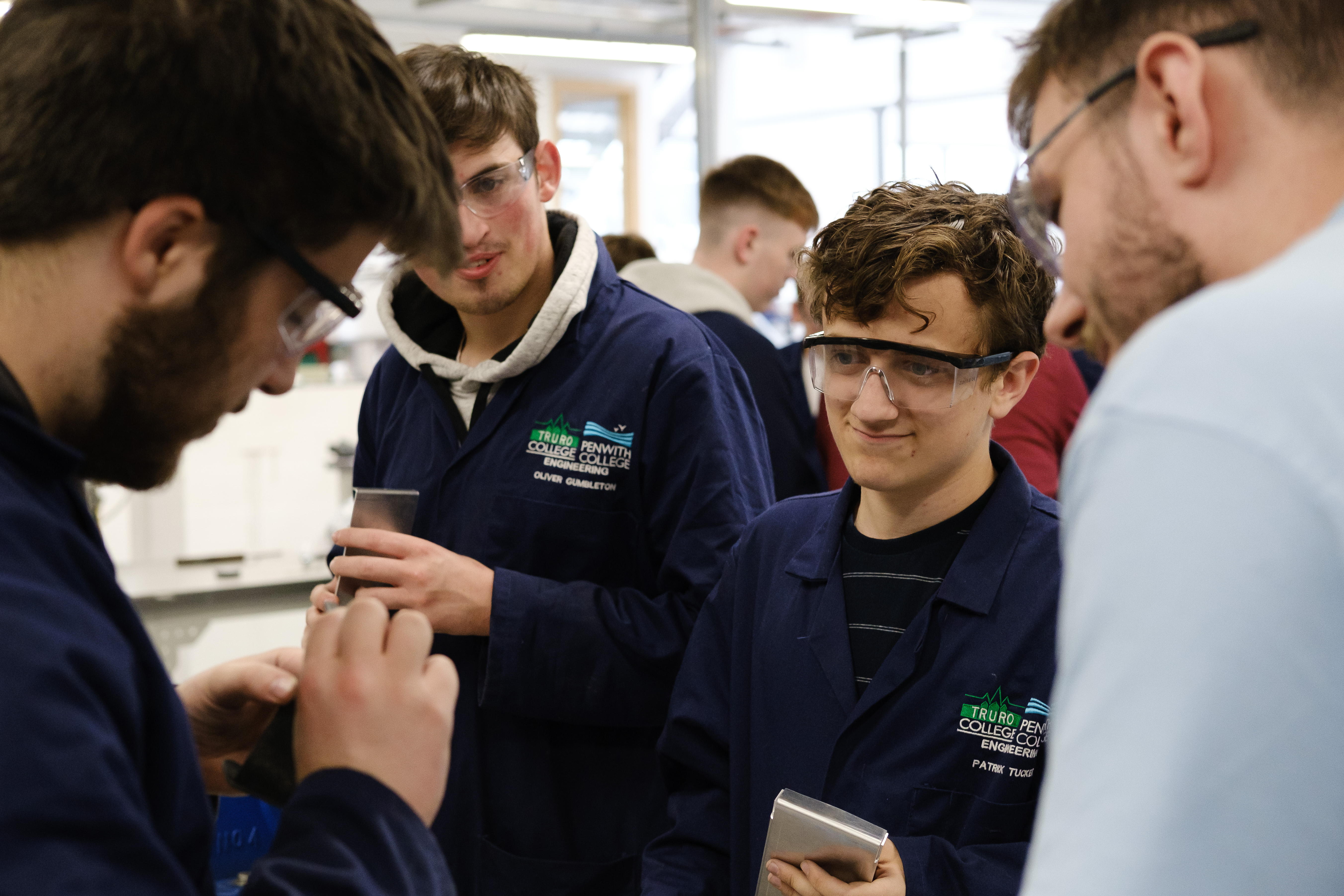 Students looking and each other's metal work