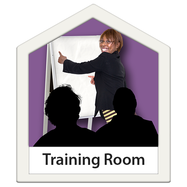 Lady pointing at flip chart smiling. 'Training Room' is written