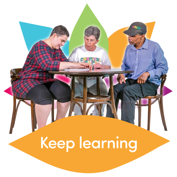 Three people sat around a table with the words 'Keep Learning' written