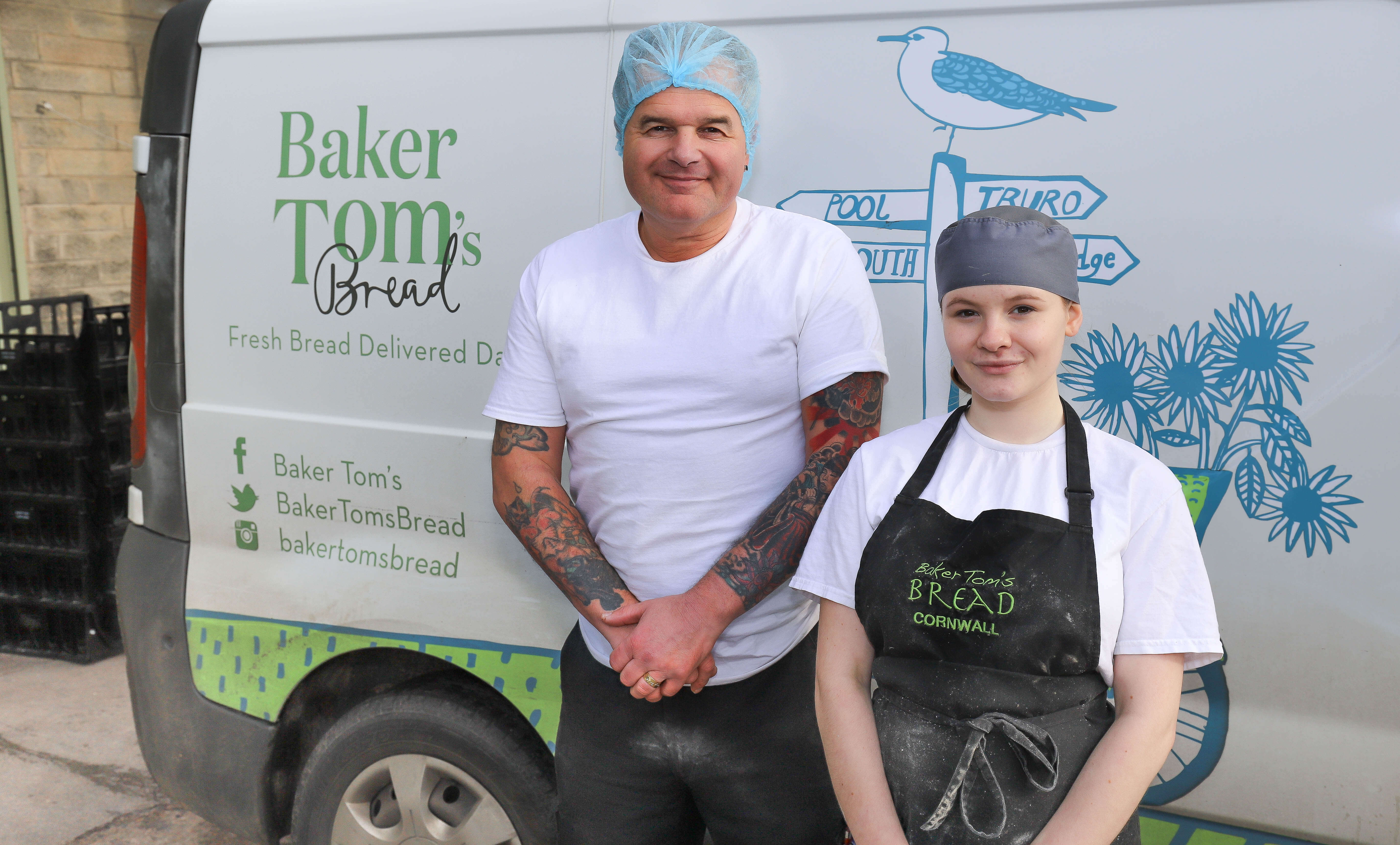 Two bakers stood against a Baker Toms van