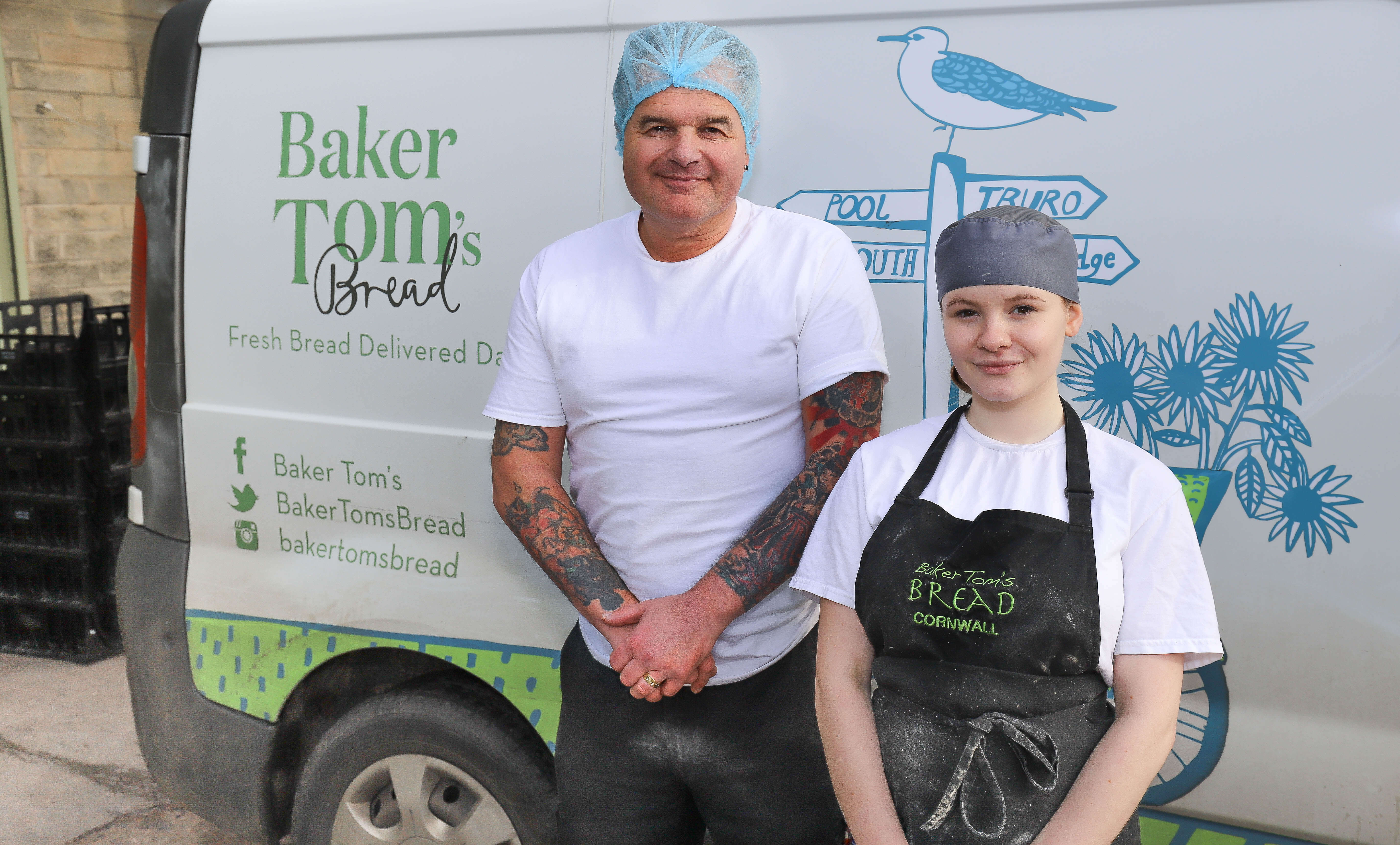 Two bakers stood against a Baker Toms van