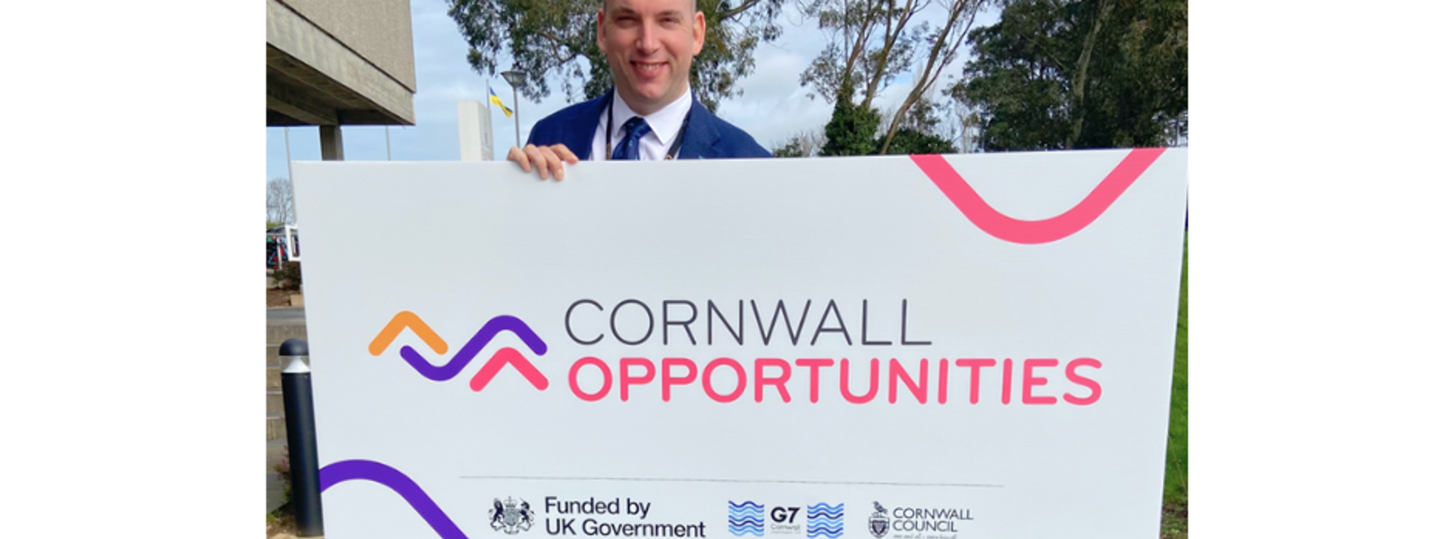 Cllr Louis Gardner pictured holding a Cornwall Opportunities sign