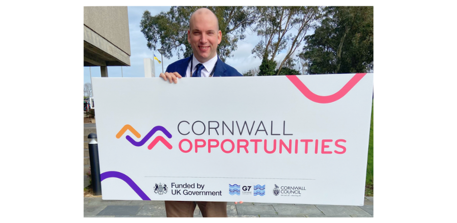 Cllr Louis Gardner pictured holding a Cornwall Opportunities sign
