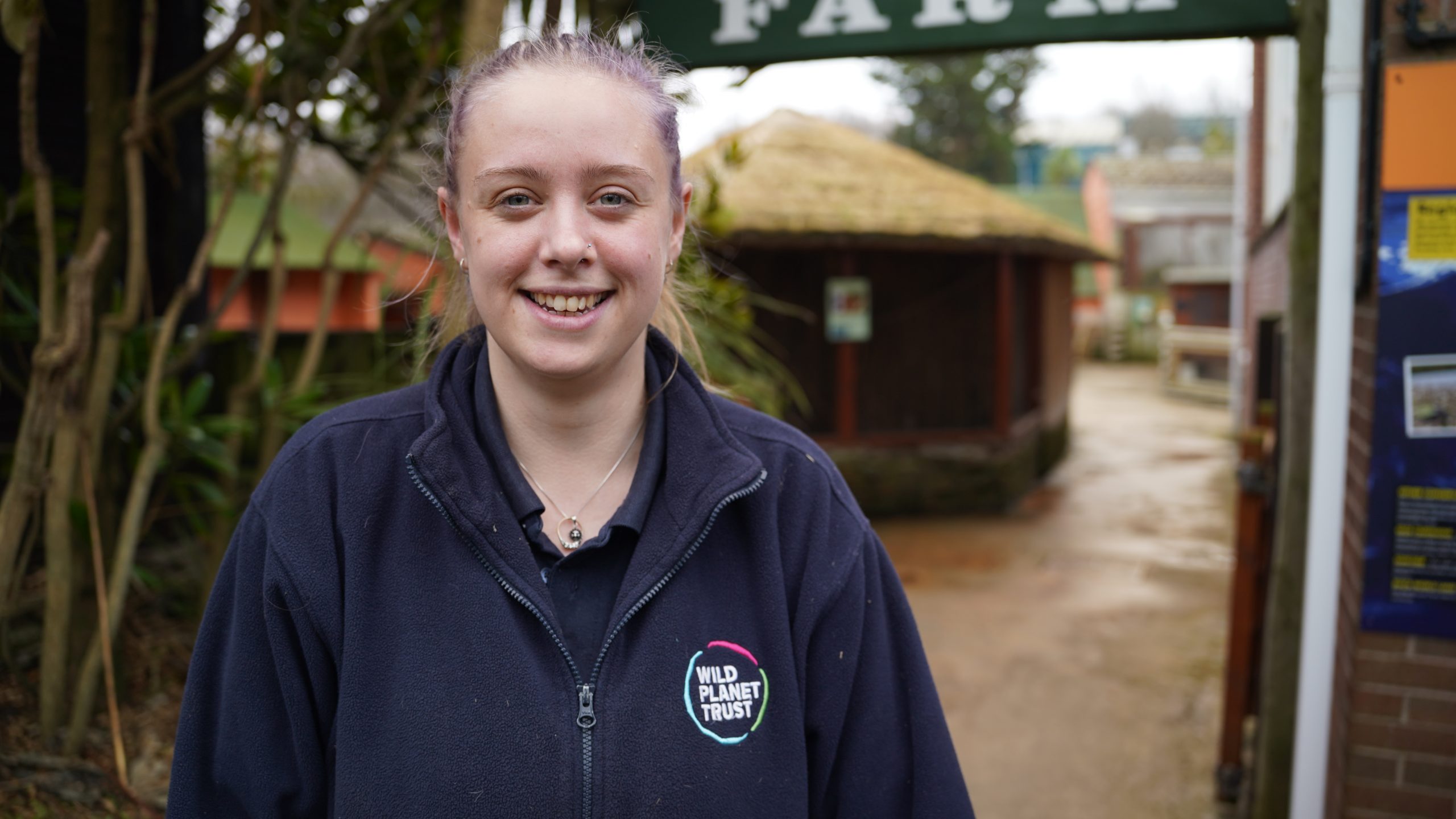 Megan Hing smiling at camera with huts in the background